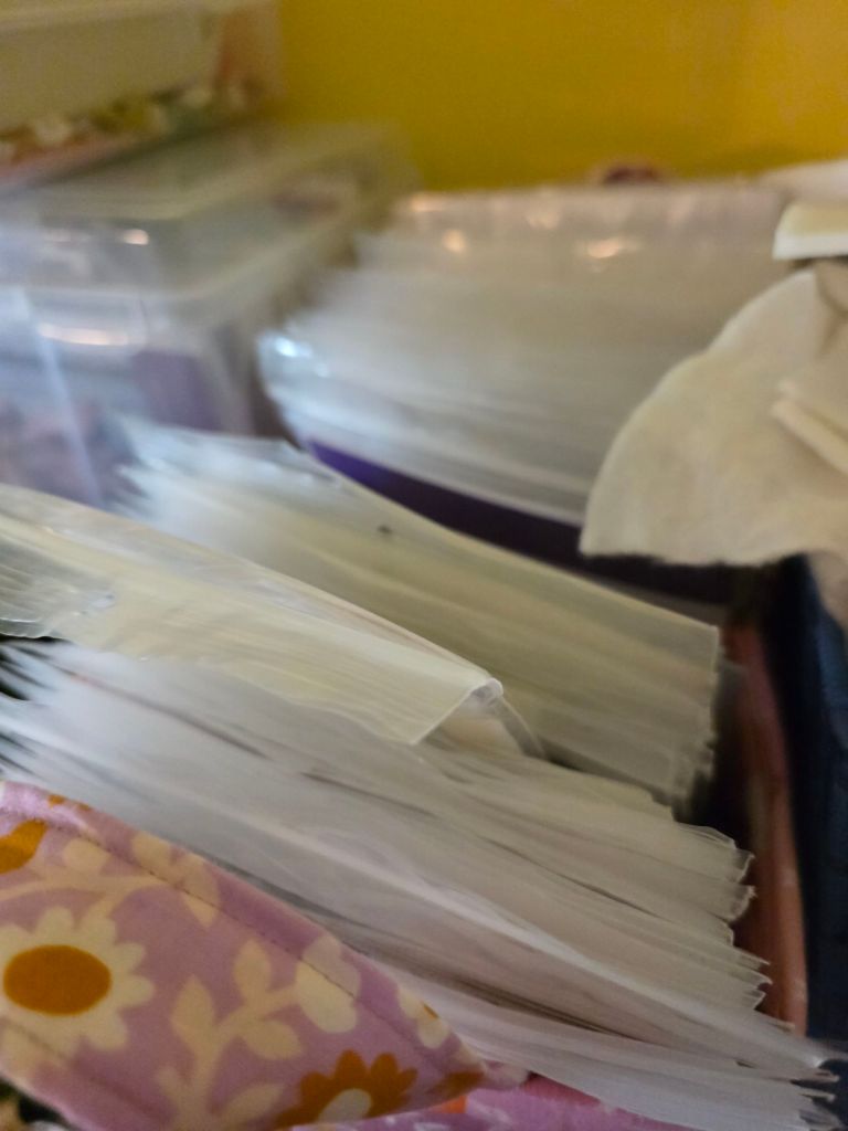 Close-up of a storage container filled with organized plastic sleeves and documents, with a colorful fabric edge visible.