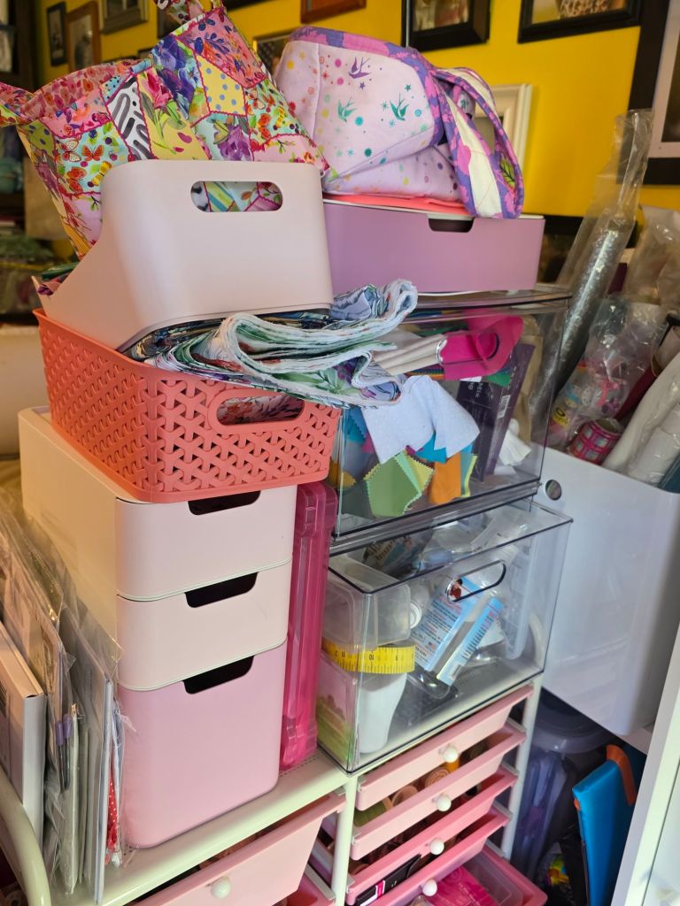 A colorful assortment of storage bins and bags stacked on a shelving unit, filled with various crafting materials and supplies.
